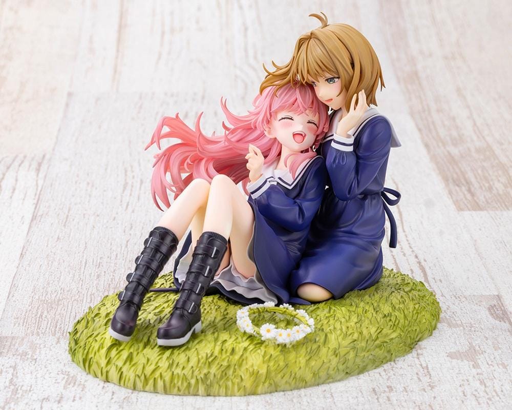 I Want to Love You Till Your Dying Day Sheena & Mimi 1/8 Scale Figure featuring pink-haired Sheena smiling with her eyes closed while leaning against blonde-haired Mimi. Both wear navy-blue school-inspired dresses and sit together on a textured grassy display base decorated with a white daisy flower crown.