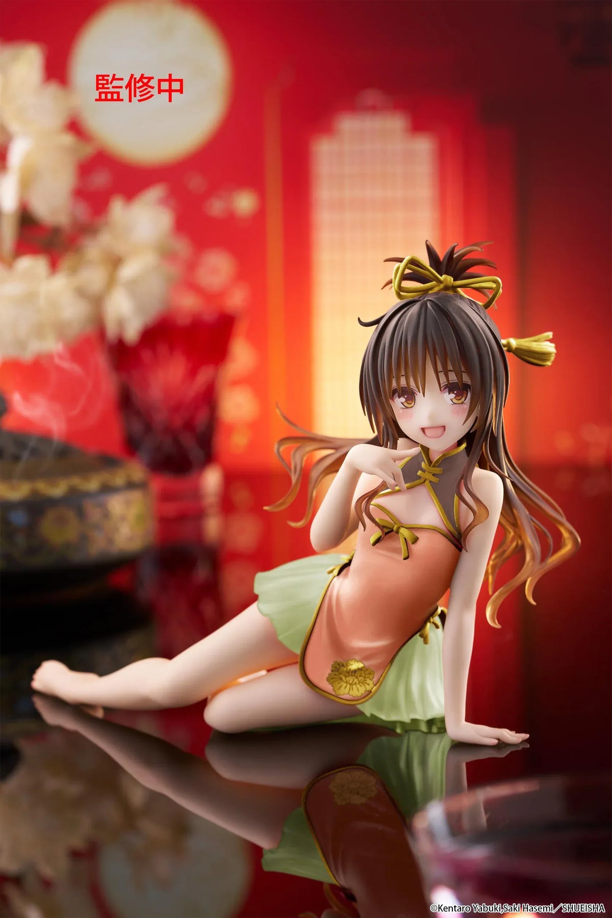 To Love-Ru Darkness Desktop Cute Mikan Yuki Chinese Dress Ver. Figure (Rerelease) featuring a brown-haired anime girl with golden eyes wearing an orange Chinese-style dress with gold trim, a light green ruffled skirt, and decorative hair ribbons in a seated pose.