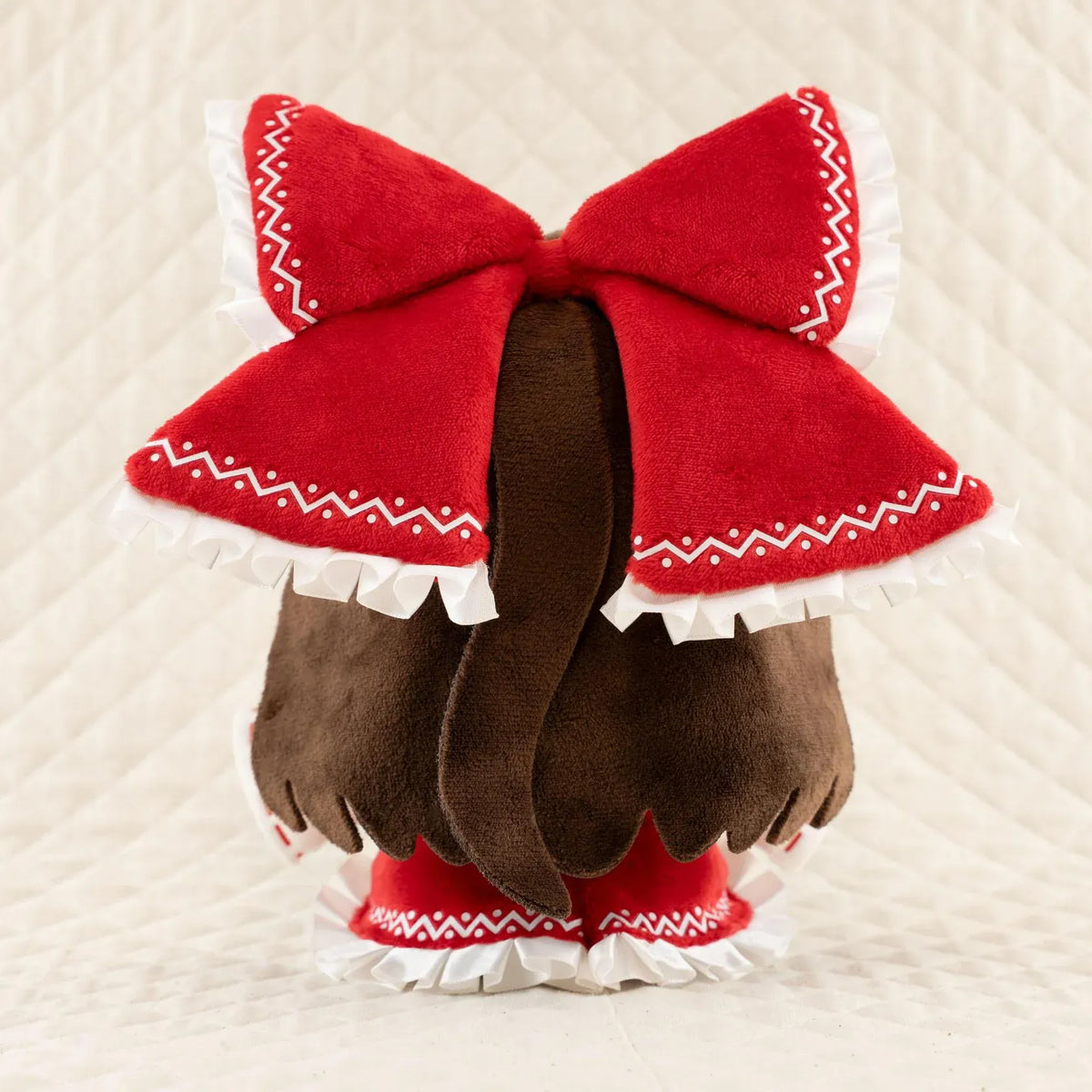 Touhou Project Chai Chara Project Reimu Hakurei Plushie featuring brown hair, embroidered brown eyes, an oversized red hair bow, a red and white shrine maiden outfit, and a cute seated chibi design.