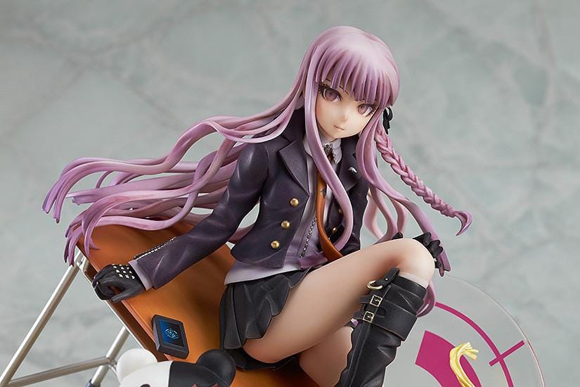 Kyoko Kirigiri 1/8 scale figure seated on a tilted classroom desk, with Monokuma, a basketball, and scattered furniture on a pink-accented base.
