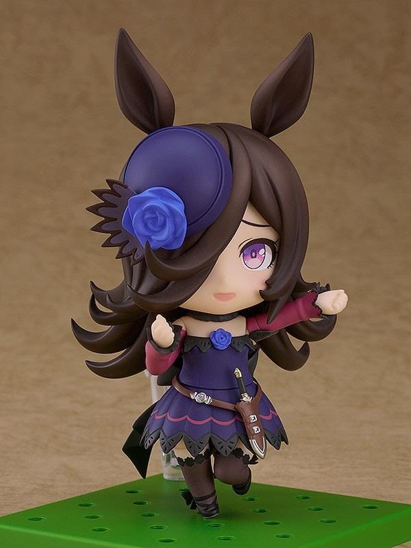Umamusume Pretty Derby Nendoroid Rice Shower Figure (Rerelease) featuring a brown-haired horse girl with purple eyes, a miniature hat decorated with a blue rose, and an elegant purple and black racing outfit.