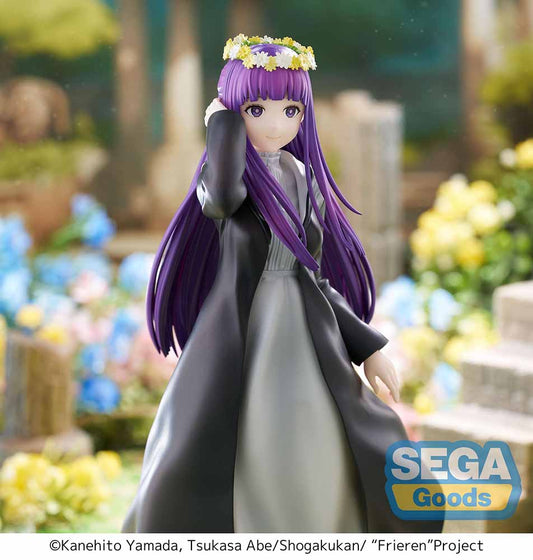 Frieren: Beyond Journey's End Luminasta Fern (Flower Garden) Figure featuring Fern in a long black coat, gray dress, and daisy crown on a grass-textured hexagonal base, set against a white background.