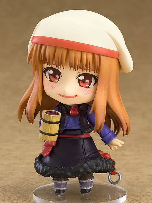 Spice and Wolf Nendoroid No.728 Holo reissue, featuring the harvest deity with amber hair and fox ears, holding a red apple, adorned in a crimson bow and a violet and black dress with a fluffy skirt.