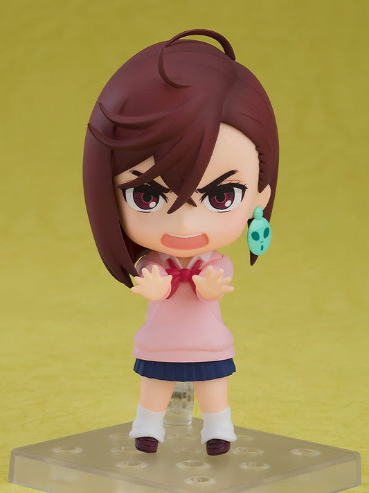 Dandadan Nendoroid No.2701 Momo, featuring the character in a pink sweater and navy skirt, with a distinctive alien earring accessory.
