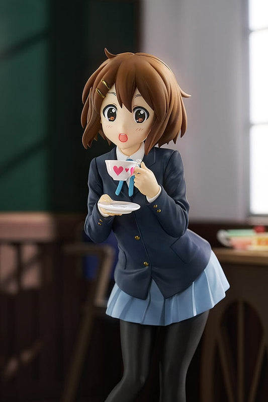 K-On! Pop Up Parade L Yui Hirasawa figure in a playful pose, holding a tea cup with a heart design, dressed in a school uniform with navy blazer and pleated skirt.
