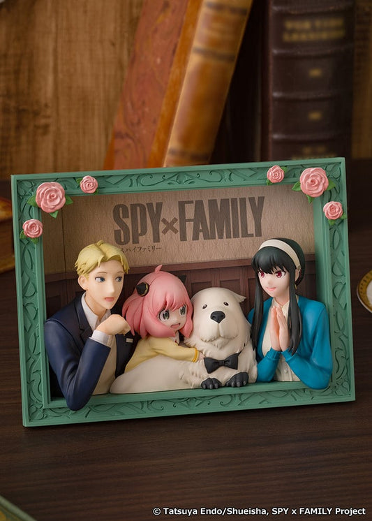 Spy x Family The Forgers Picture Frame Figure featuring Loid, Yor, Anya, and Bond in a decorative green frame with floral accents, recreating a wholesome family moment.