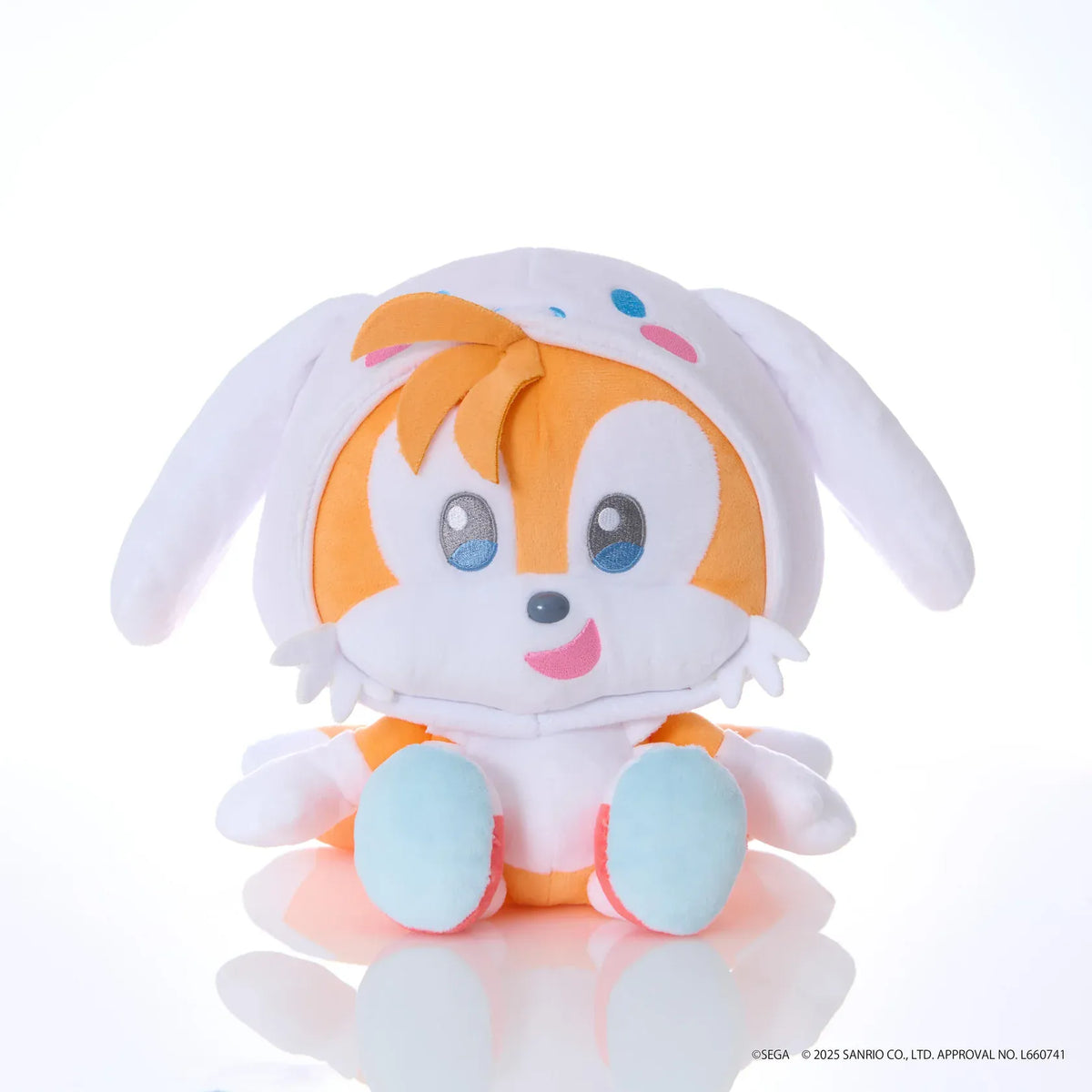Sonic & Friends x Sanrio Tails medium plush wearing a white Cinnamoroll hood with long ears, blue eyes, and pink cheeks.