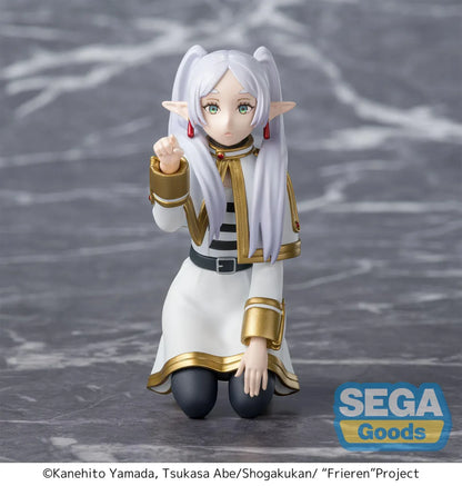 Perching figure of Frieren from Frieren: Beyond Journey’s End kneeling on a stone-like base, reaching forward to poke something, with long silver hair, elf ears, and a white-and-gold outfit.