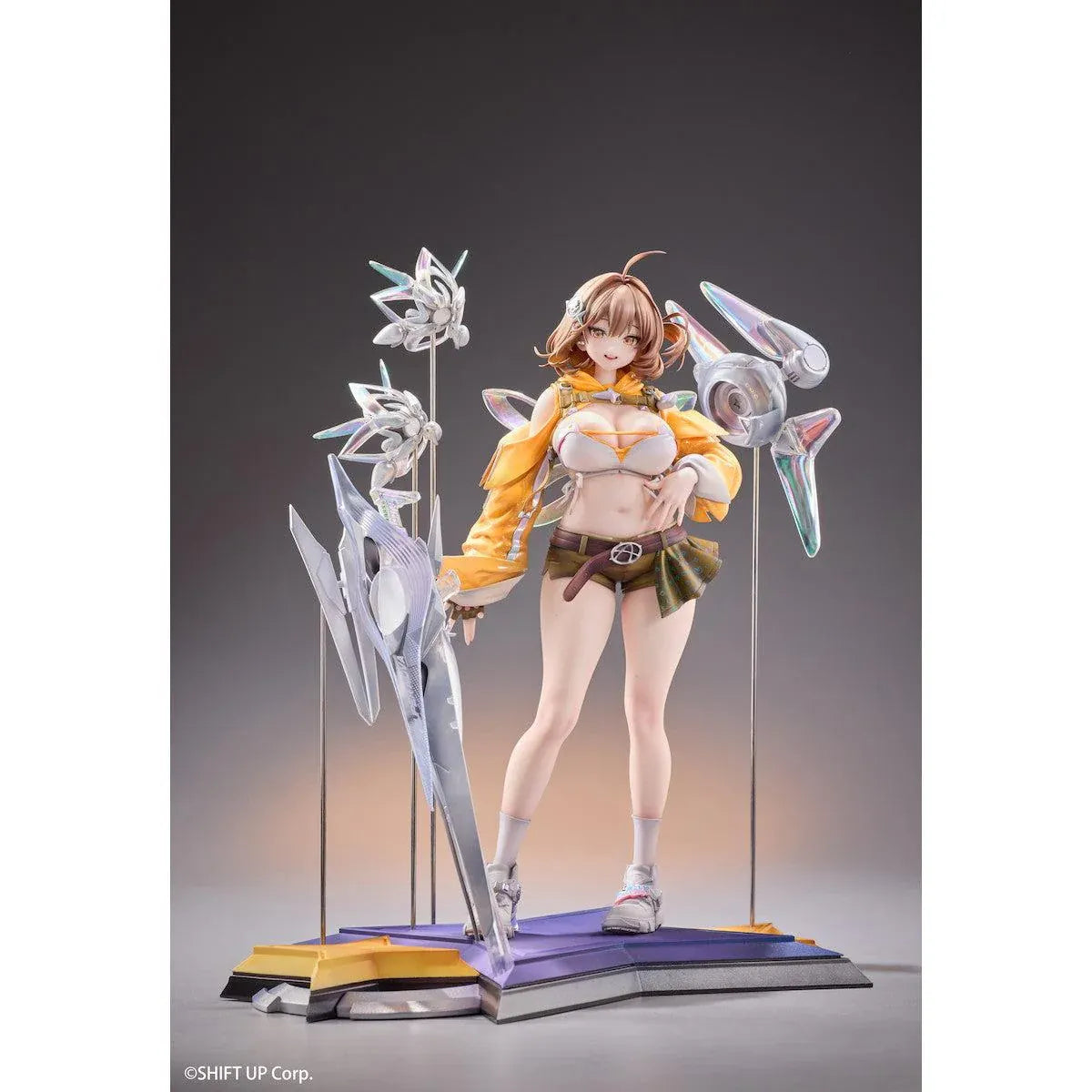 GODDESS OF VICTORY: NIKKE Anis: Star 1/7 Scale Figure featuring a brown-haired anime girl wearing a yellow jacket, white top, olive-green shorts, and sneakers, surrounded by futuristic floating mechanical accessories on a detailed display base.