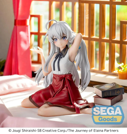Figure of Elaina from Wandering Witch: The Journey of Elaina sitting on a bed in a white blouse and red skirt, with long silver hair and books beside her, in a sunlit room.
