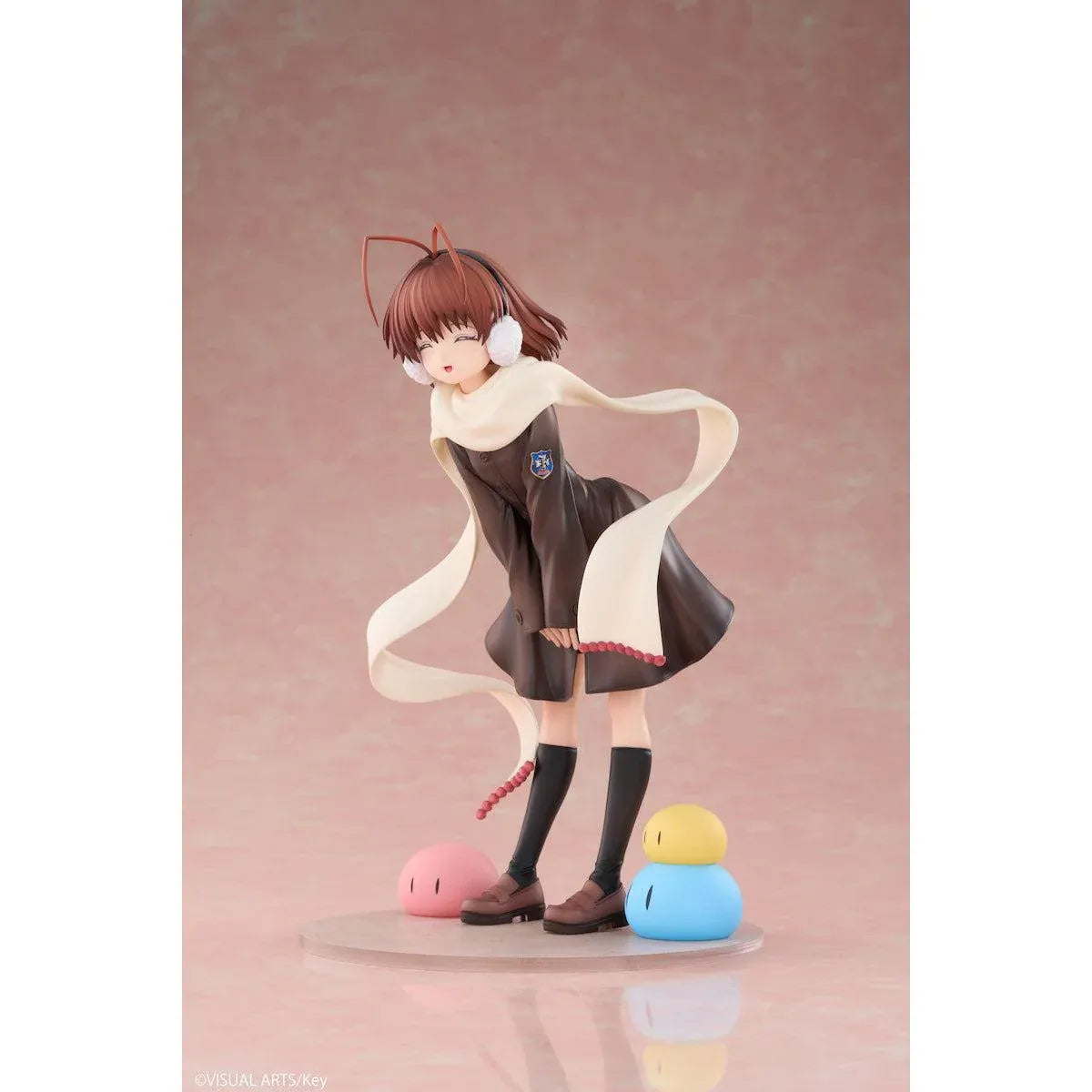 CLANNAD Nagisa Furukawa 1/6 Scale Figure featuring a smiling brown-haired anime girl wearing a dark school uniform, cream-colored scarf, white earmuffs, and black knee-high socks, surrounded by colorful Dango Daikazoku characters.