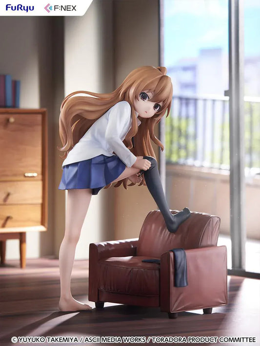1/7 scale Toradora figure of Taiga Aisaka at home, barefoot and leaning on a leather armchair while pulling on a black thigh-high sock, wearing her school shirt and blue skirt.