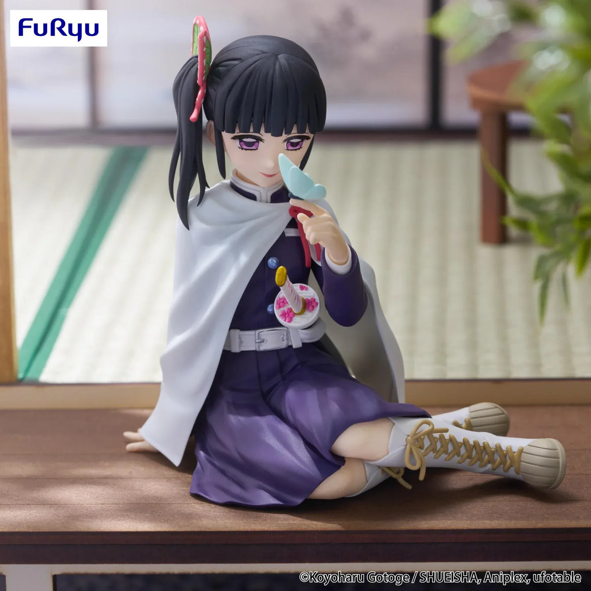 Kanao Tsuyuri Noodle Stopper figure seated in her Demon Slayer uniform and white cape while holding a blue butterfly.