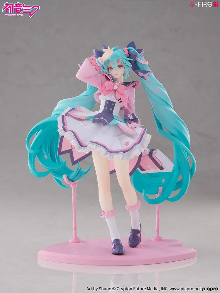 Hatsune Miku New School Term figure with turquoise twin-tails, a pink and white ruffled outfit, purple bows, and flower accents on a pink base.