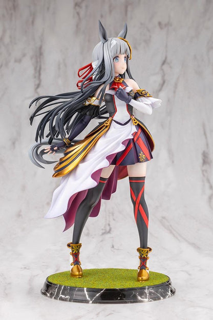 Umamusume Pretty Derby Chrono Genesis 1/7 Scale Figure featuring a silver-gray-haired horse girl with blue eyes, horse ears, and a flowing white, black, red, and gold racing outfit standing on a grassy display base.