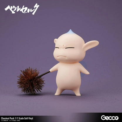 Berserk Chestnut Puck 1/1 Scale Soft Vinyl Figure by Gecco featuring a small cream-colored elf with oversized pointed ears, a tiny blue hair tuft, closed eyes, a grumpy expression, and a rounded body holding a large spiky brown chestnut burr.