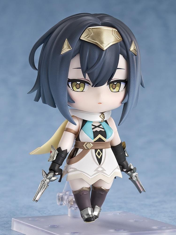Stella Sora Nendoroid Amber Figure featuring a dark blue-haired anime girl with golden eyes wearing a white and teal outfit with gold accents, black gloves, armored boots, and holding two silver weapons.