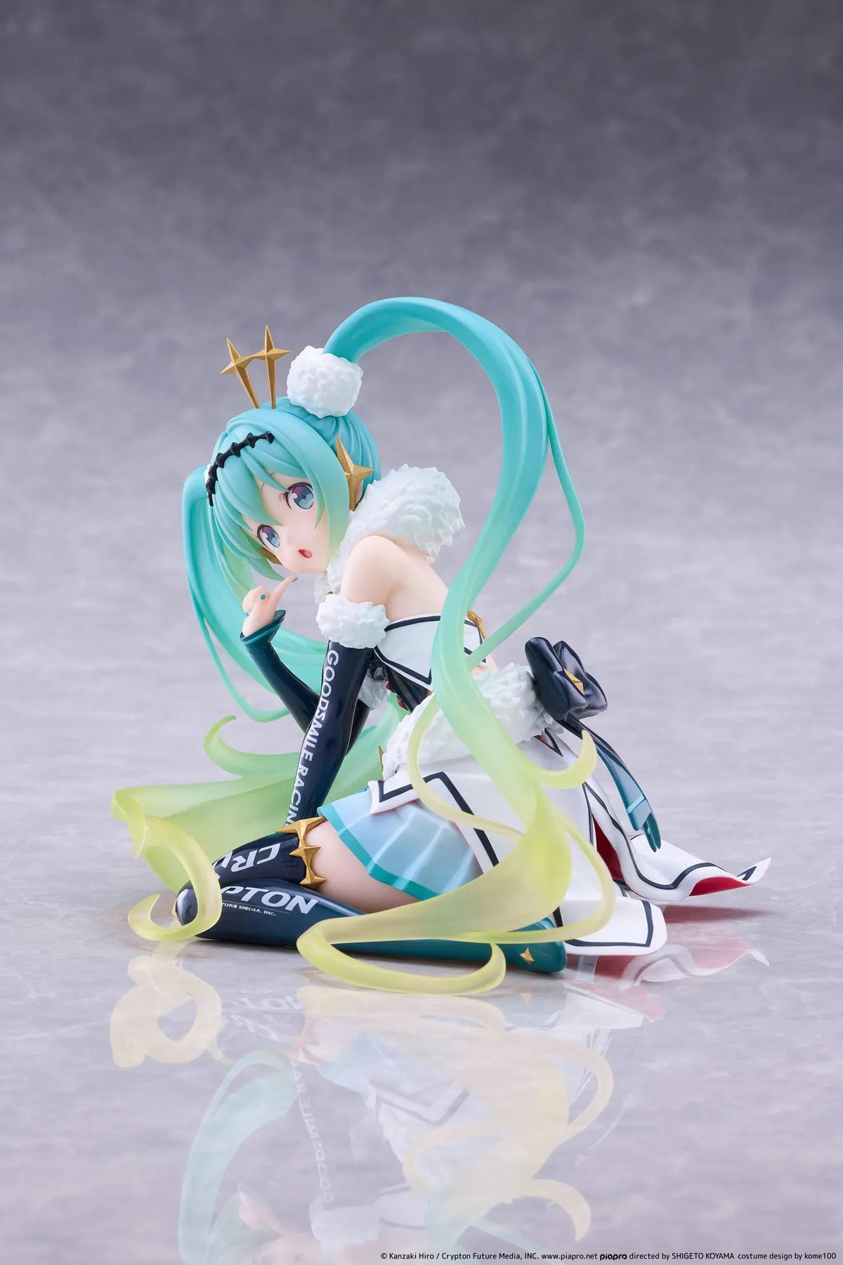 Racing Miku 2018 Ver. Round 8 figure seated in a white, black, and turquoise racing outfit with long gradient twin tails.