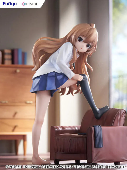 1/7 scale Toradora figure of Taiga Aisaka at home, barefoot and leaning on a leather armchair while pulling on a black thigh-high sock, wearing her school shirt and blue skirt.