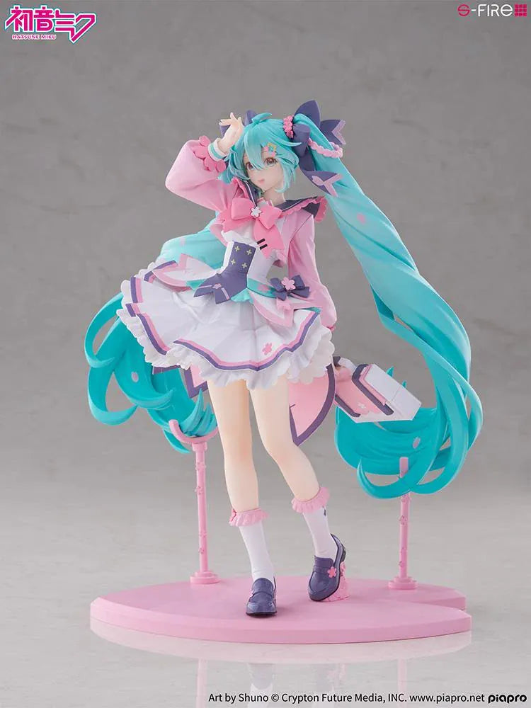 Hatsune Miku New School Term figure with turquoise twin-tails, a pink and white ruffled outfit, purple bows, and flower accents on a pink base.