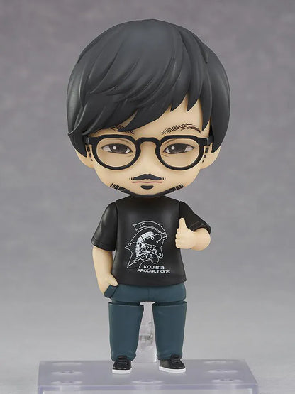 Kojima Productions Nendoroid Hideo Kojima Figure with glasses, black Kojima Productions shirt, and thumbs-up pose