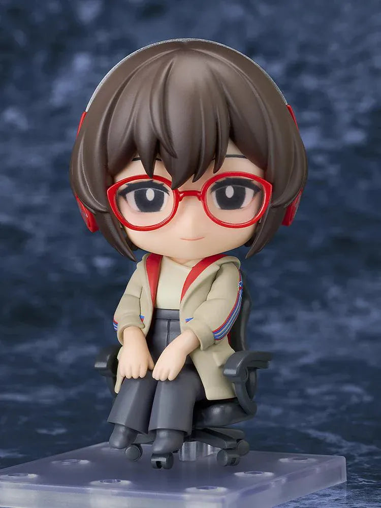 Nendoroid Satone figure seated in a black office chair, wearing red glasses, red headphones, a beige jacket, and dark gray trousers.