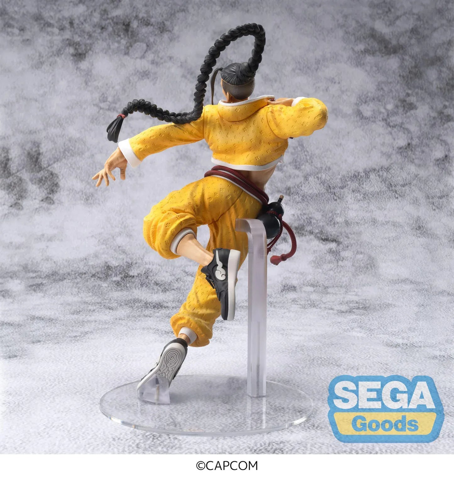 Street Fighter 6 FiGURiZMa Jamie figure in a dynamic martial arts pose with signature yellow outfit and braided hair