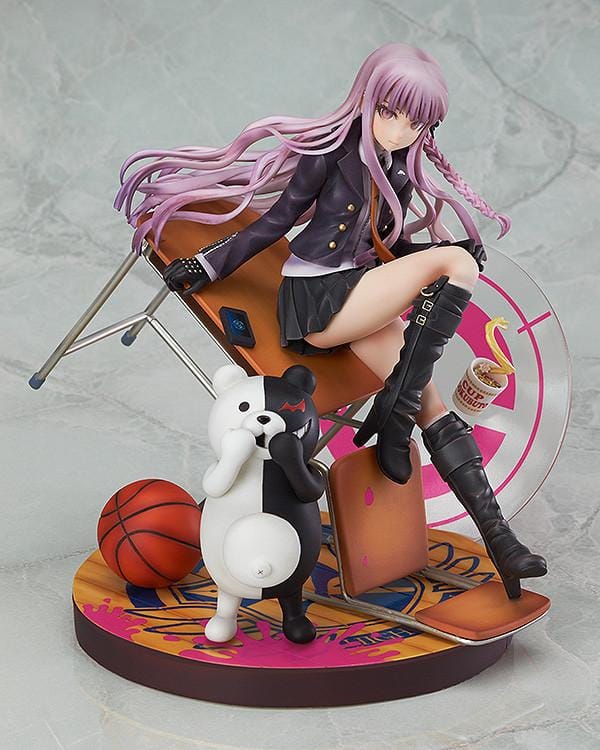 Kyoko Kirigiri 1/8 scale figure seated on a tilted classroom desk, with Monokuma, a basketball, and scattered furniture on a pink-accented base.