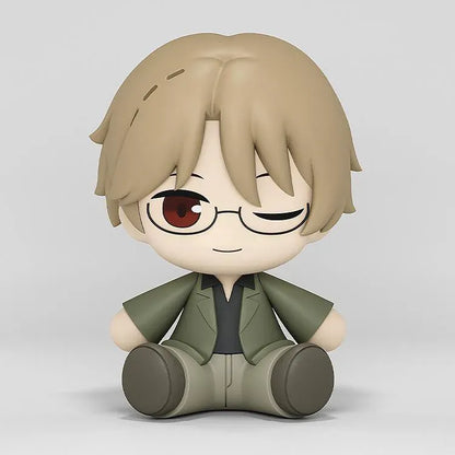 Shuichi Natori Huggy Good Smile figure seated in a green jacket and glasses with a playful winking expression.