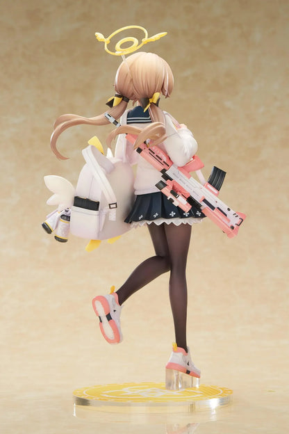 Blue Archive Hifumi figure smiling with one foot lifted, wearing a white cardigan and navy skirt, carrying a bird-themed bag and rifle on a yellow base.