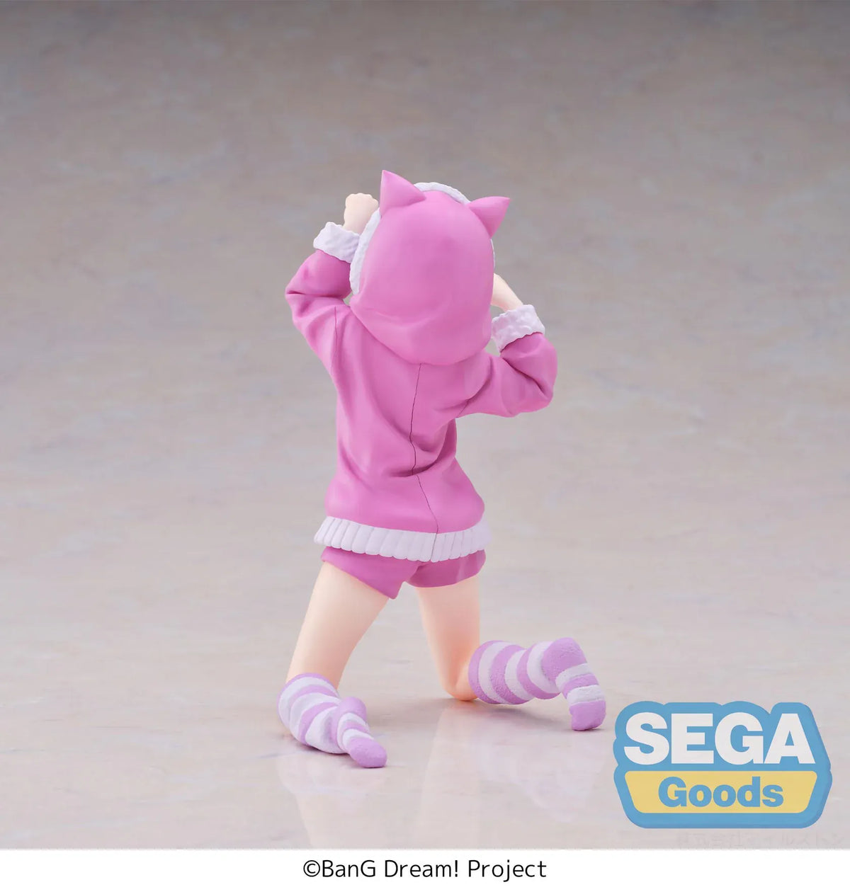 BanG Dream! Nyamu Yutenji Pajama Party figure kneeling in pink pajamas with a cat-ear hood, purple hair, striped socks, and both hands raised.