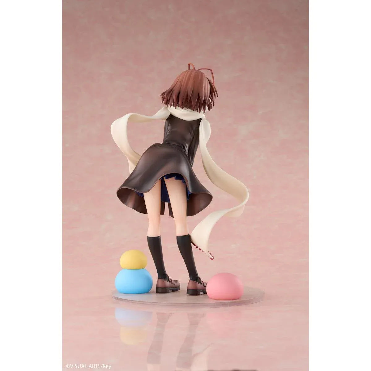 CLANNAD Nagisa Furukawa 1/6 Scale Figure featuring a smiling brown-haired anime girl wearing a dark school uniform, cream-colored scarf, white earmuffs, and black knee-high socks, surrounded by colorful Dango Daikazoku characters.