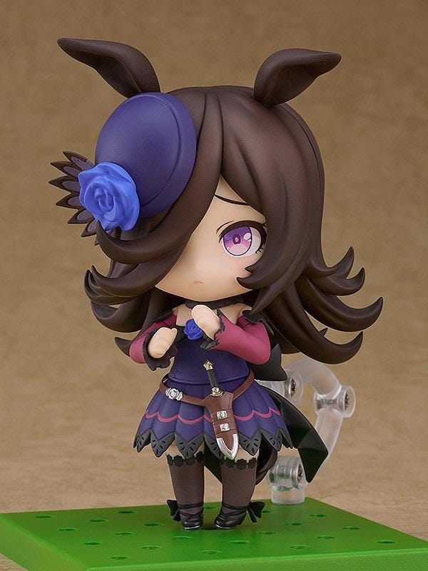 Umamusume Pretty Derby Nendoroid Rice Shower Figure (Rerelease) featuring a brown-haired horse girl with purple eyes, a miniature hat decorated with a blue rose, and an elegant purple and black racing outfit.