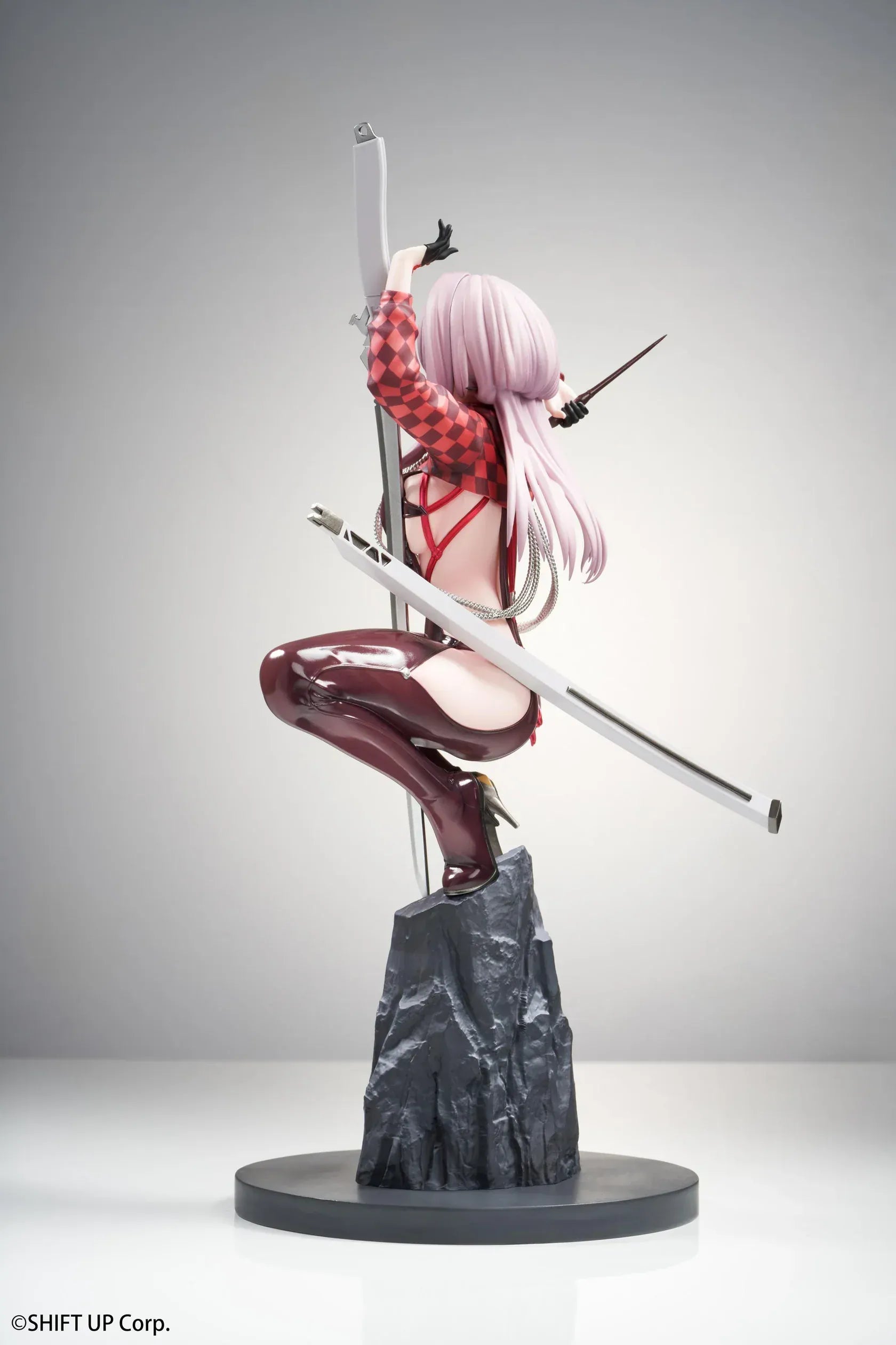 Scarlet Racer's High scale figure from Goddess of Victory: Nikke, crouching on a rocky base with weapons drawn and glossy red combat suit.