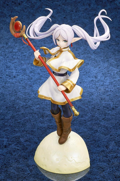Frieren vs Aura 1/7 scale figure holding a red staff while wearing her white-and-gold mage outfit on a rounded display base.