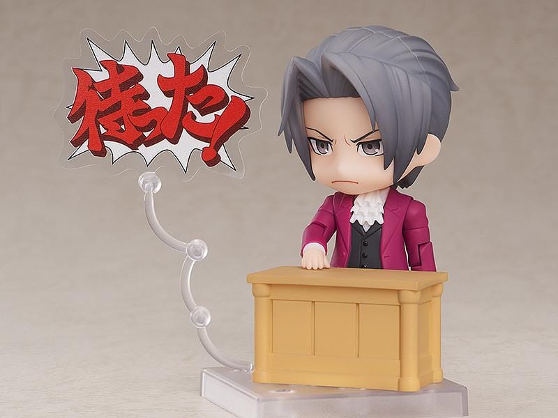 Ace Attorney Miles Edgeworth Nendoroid rerelease figure wearing a burgundy suit and pointing beside a Japanese Objection effect part.