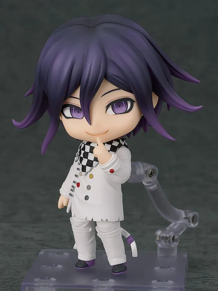 Nendoroid Kokichi Oma with purple hair, violet eyes, a black peaked cap and cape, and a white outfit, smiling with both arms extended.