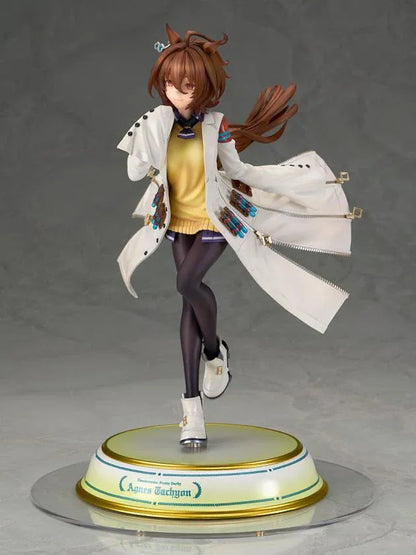 Agnes Tachyon 1/7 scale figure wearing an oversized white laboratory coat, yellow sweater, and dark tights on a decorative base.