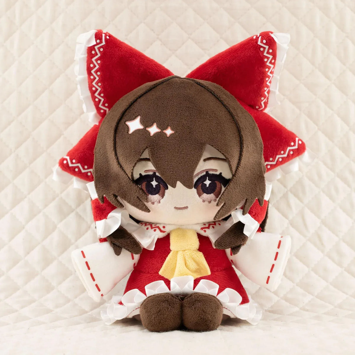 Touhou Project Chai Chara Project Reimu Hakurei Plushie featuring brown hair, embroidered brown eyes, an oversized red hair bow, a red and white shrine maiden outfit, and a cute seated chibi design.