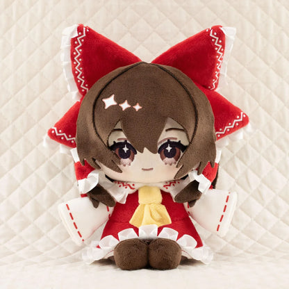 Touhou Project Chai Chara Project Reimu Hakurei Plushie featuring brown hair, embroidered brown eyes, an oversized red hair bow, a red and white shrine maiden outfit, and a cute seated chibi design.