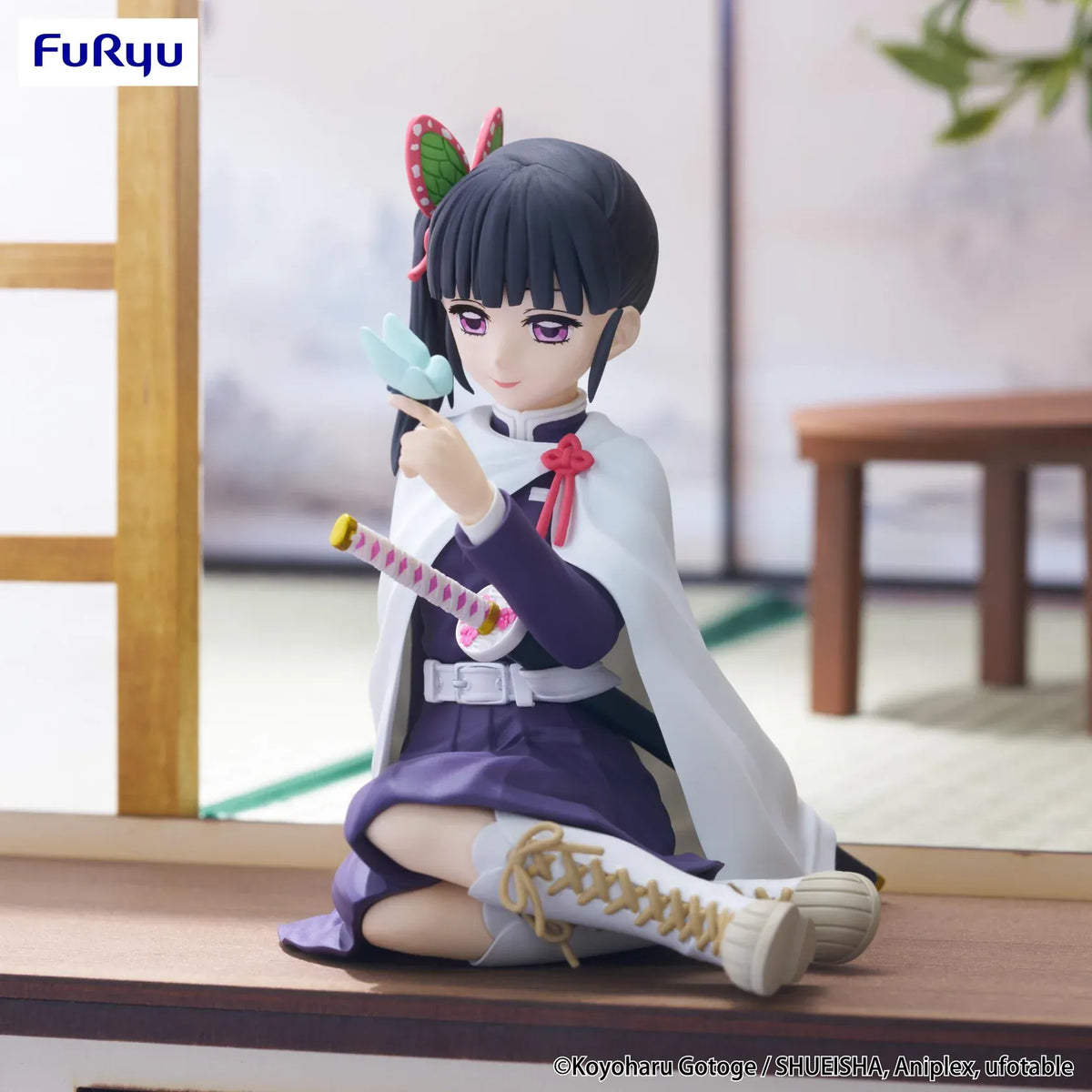 Kanao Tsuyuri Noodle Stopper figure seated in her Demon Slayer uniform and white cape while holding a blue butterfly.