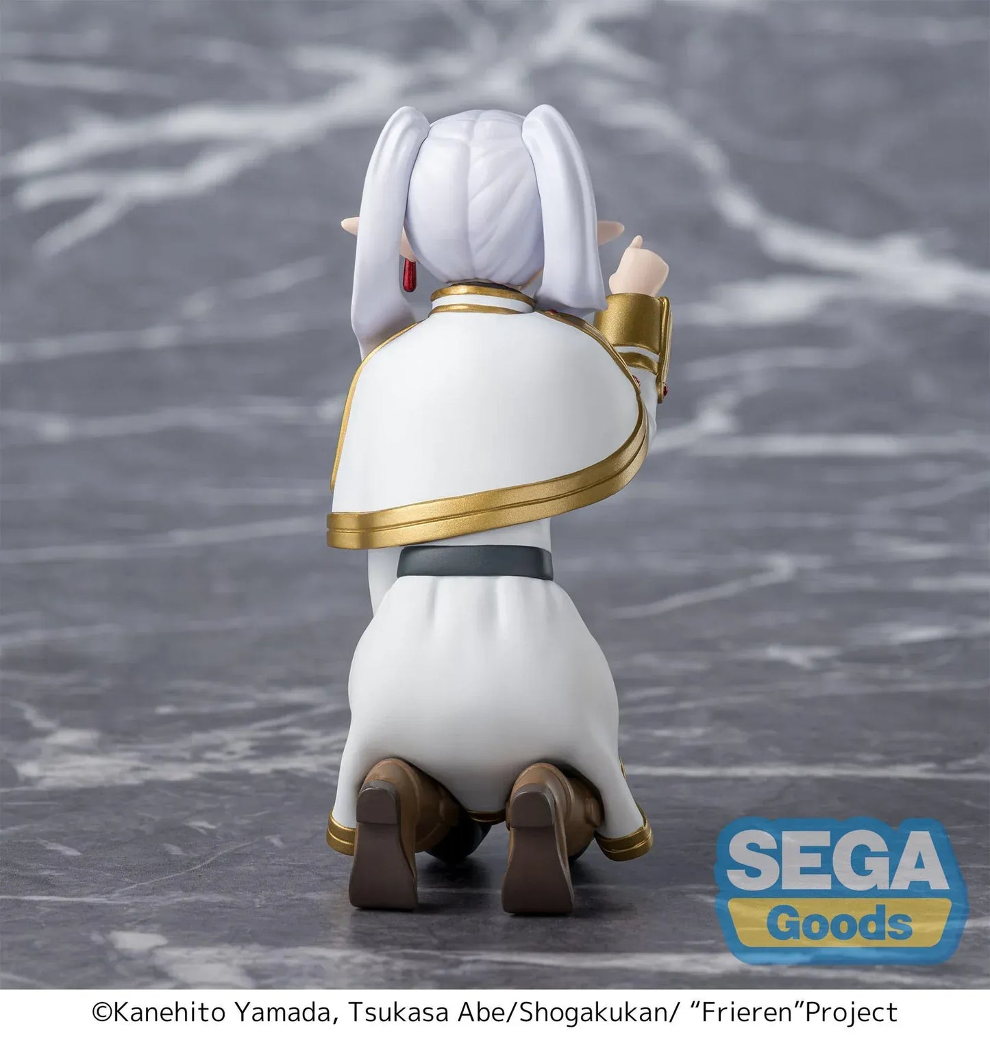 Perching figure of Frieren from Frieren: Beyond Journey’s End kneeling on a stone-like base, reaching forward to poke something, with long silver hair, elf ears, and a white-and-gold outfit.