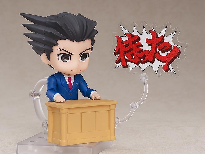Ace Attorney Phoenix Wright Nendoroid rerelease figure wearing a blue suit and pointing beside a Japanese Objection effect part.