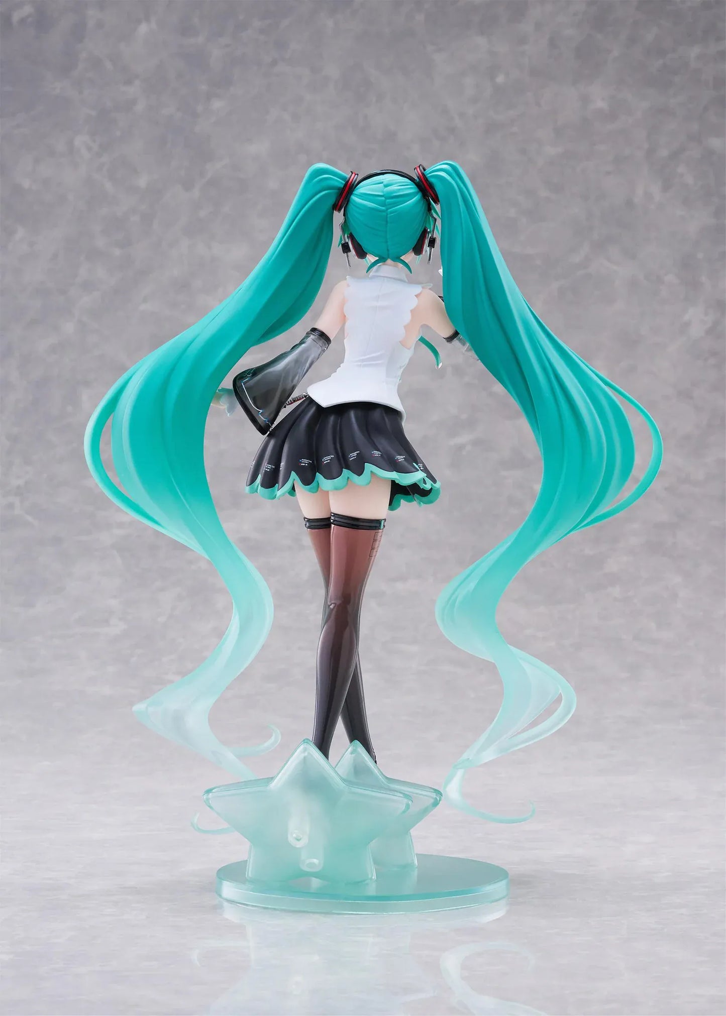 Vocaloid T-Most Hatsune Miku NT Ver. Figure featuring Miku with long teal twin tails, headphones, black-and-white outfit, wink expression, peace-sign pose, and star-themed base.