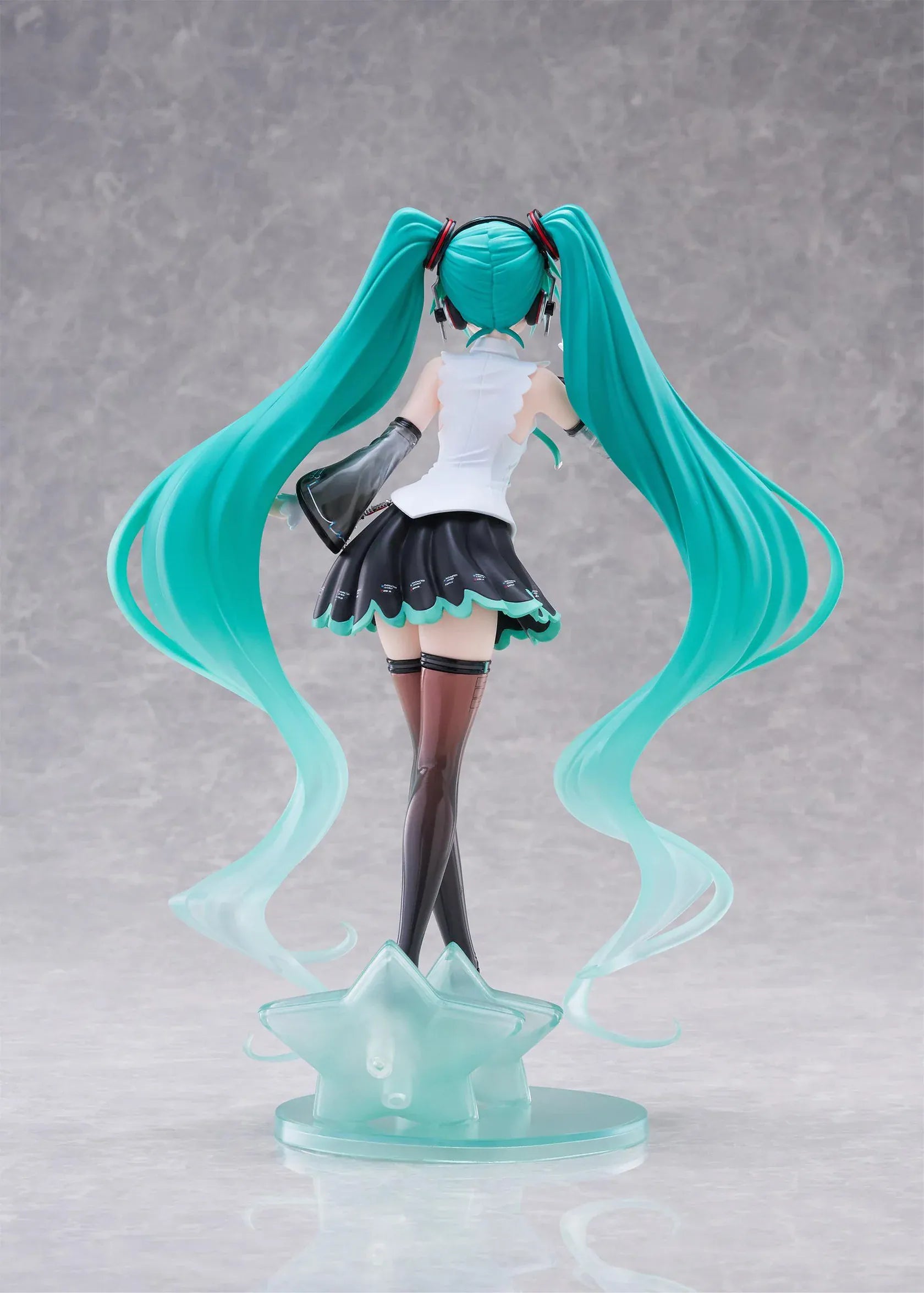 Vocaloid T-Most Hatsune Miku NT Ver. Figure featuring Miku with long teal twin tails, headphones, black-and-white outfit, wink expression, peace-sign pose, and star-themed base.
