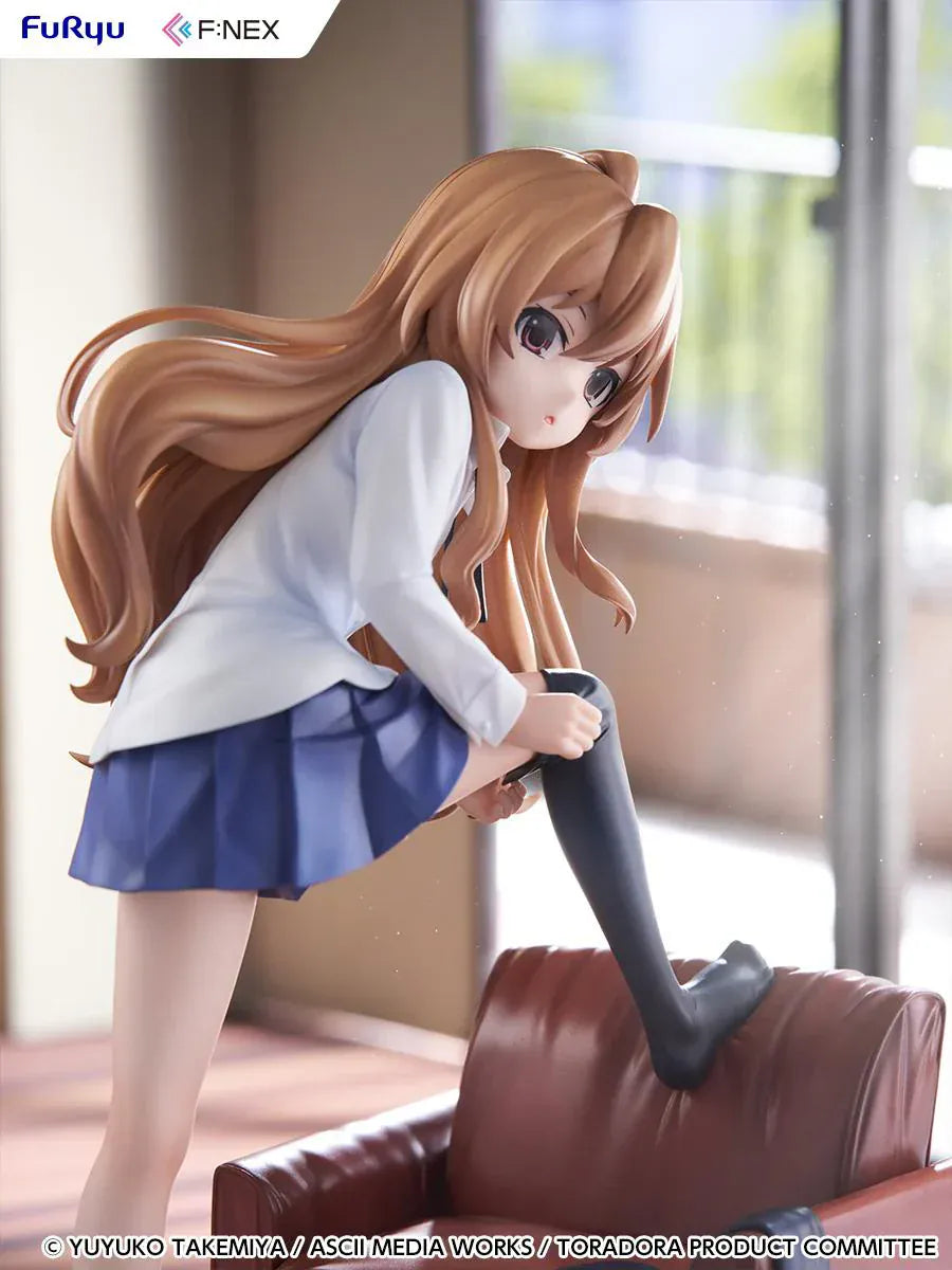 1/7 scale Toradora figure of Taiga Aisaka at home, barefoot and leaning on a leather armchair while pulling on a black thigh-high sock, wearing her school shirt and blue skirt.