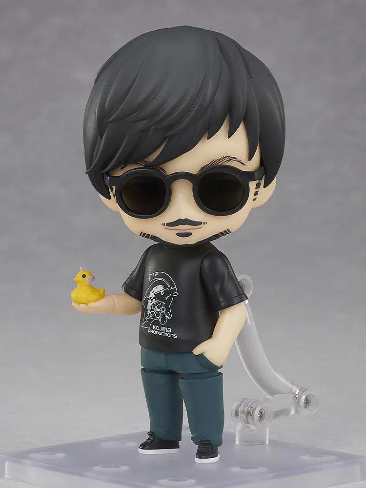 Kojima Productions Nendoroid Hideo Kojima Figure with glasses, black Kojima Productions shirt, and thumbs-up pose