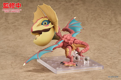 Monster Hunter Nendoroid Yian Kut-Ku with yellow ear fans, an open beak, pink-red scales, and spread wings with turquoise membranes.