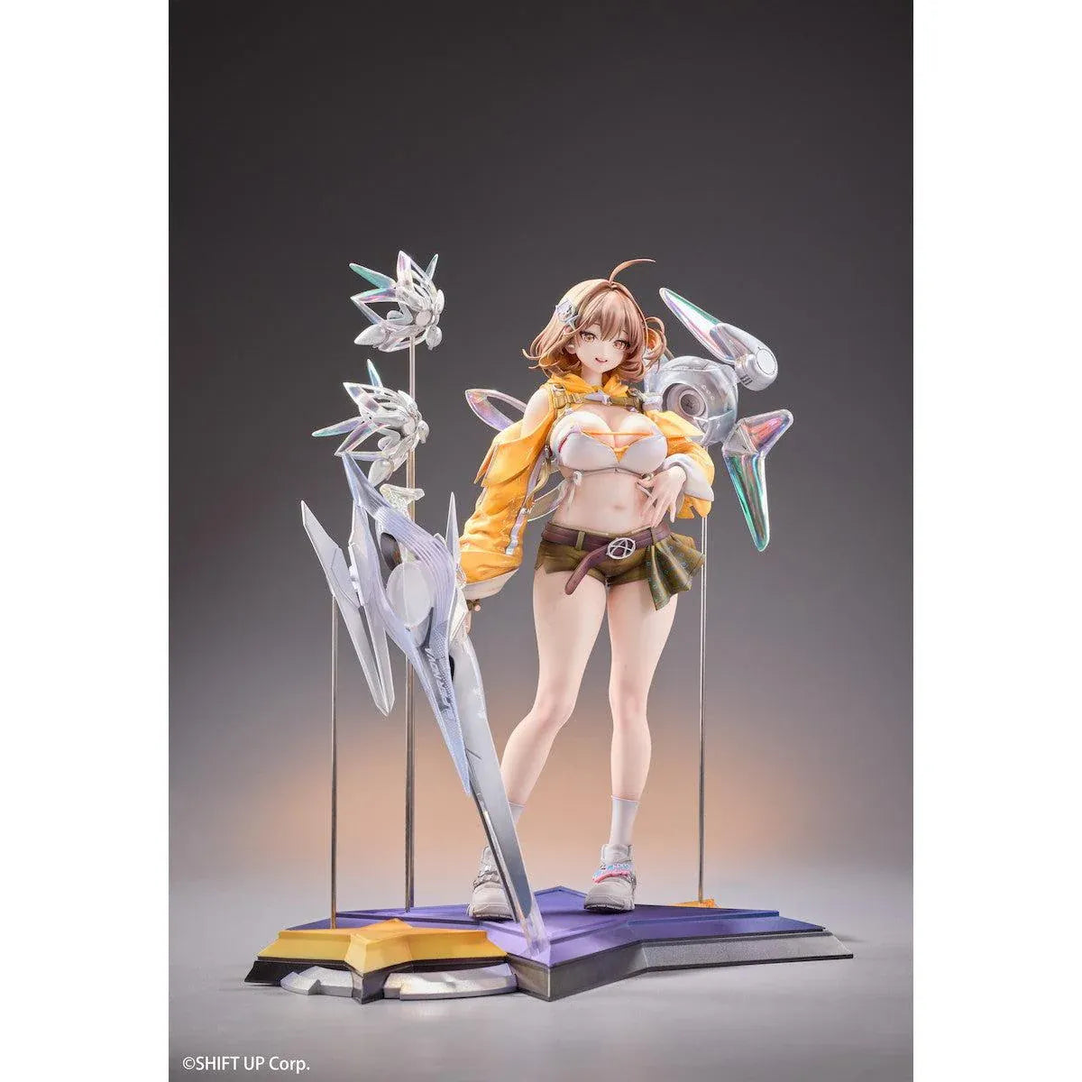 GODDESS OF VICTORY: NIKKE Anis: Star 1/7 Scale Figure featuring a brown-haired anime girl wearing a yellow jacket, white top, olive-green shorts, and sneakers, surrounded by futuristic floating mechanical accessories on a detailed display base.
