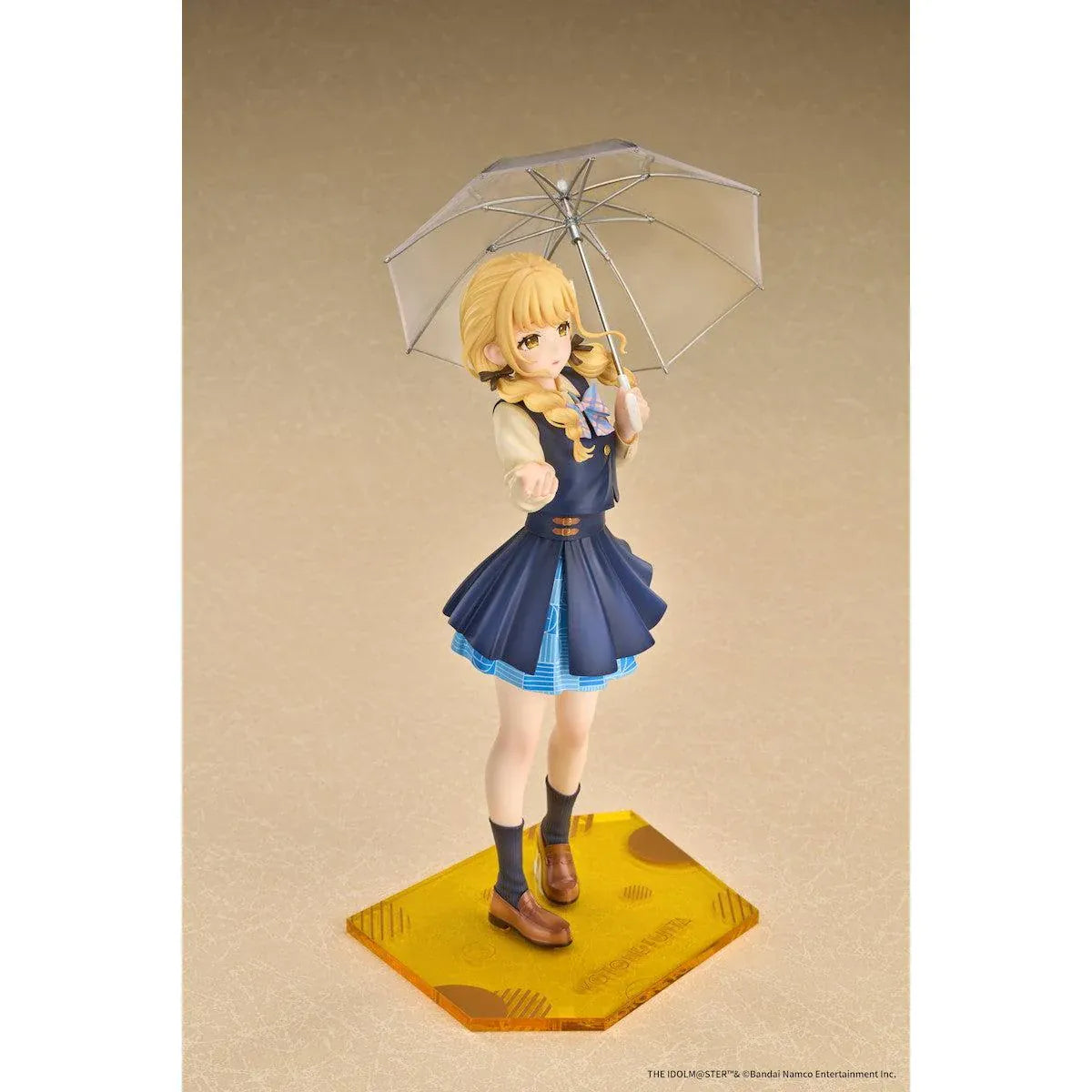 Gakuen iDOLM@STER Kotone Fujita Ameagari no Iris Before Special Training Ver. 1/7 Scale Figure featuring a blonde-haired anime girl with twin braids wearing a navy-blue school uniform and holding a transparent umbrella on a yellow display base.